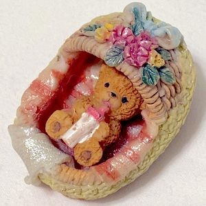 Vintage miniature baby resin bear in a basket, drinking a bottle